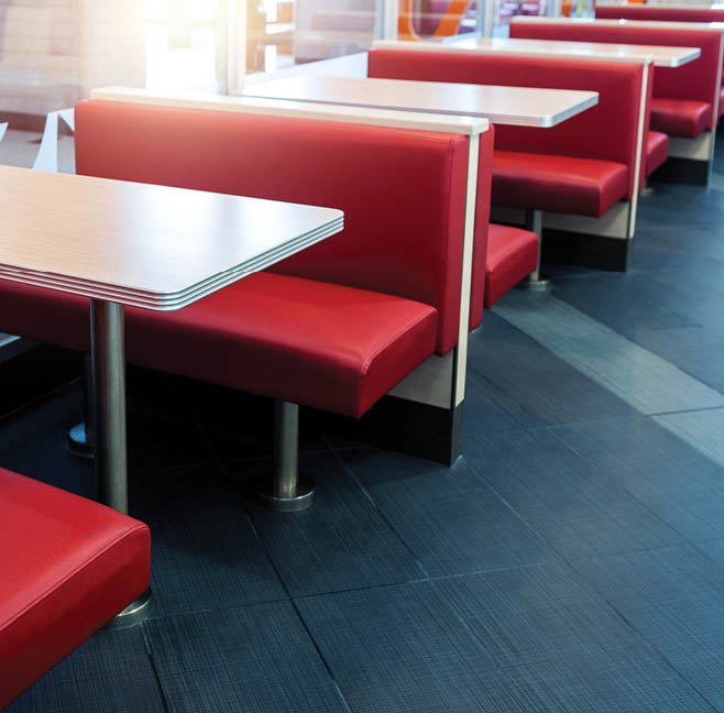 A row of red booths with silver tables and benches in a restaurant. AI generated content