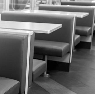 A black and white photo of a restaurant with several booths and tables. AI generated content