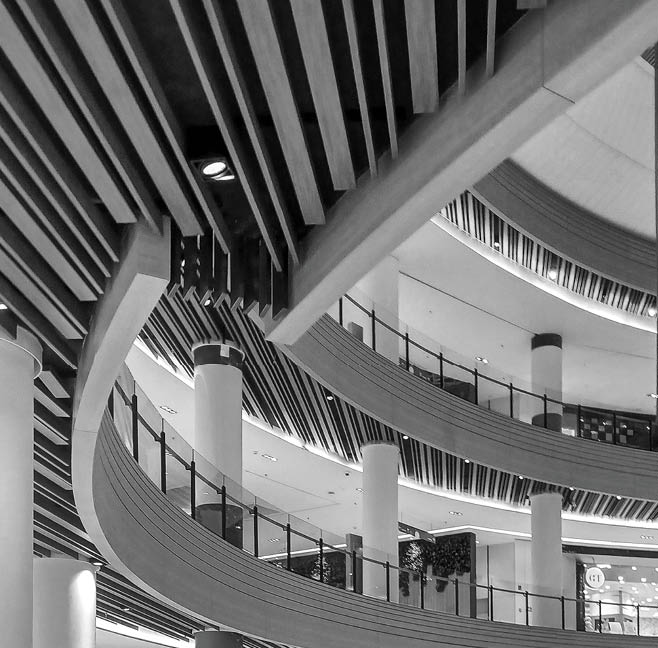 A large, modern building with a spiral staircase and a glass ceiling. AI generated content