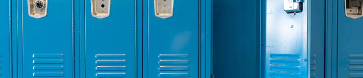 Single open empty blue metal locker along a nondescript hallway in a typical US High School. No identifiable information included and nobody in the hall.   