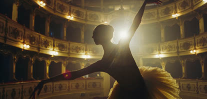Close Up of Ballerina in Pointe Shoes and White Tutu Dancing and Rehearsing on Classic Theatre Stage with Dramatic Lighting. Graceful Classical Ballet Female Dancer Performing a Choreography