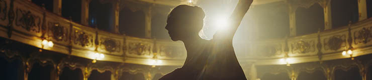 Close Up of Ballerina in Pointe Shoes and White Tutu Dancing and Rehearsing on Classic Theatre Stage with Dramatic Lighting. Graceful Classical Ballet Female Dancer Performing a Choreography