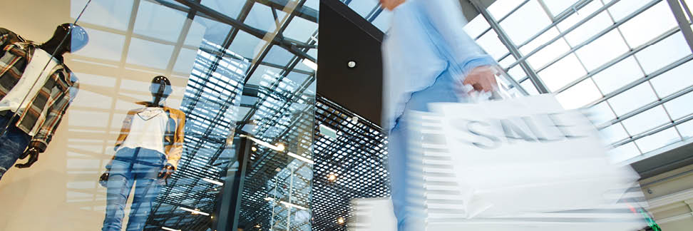 Modern girl looking for trendy clothes on black friday sale while shopping in trade center