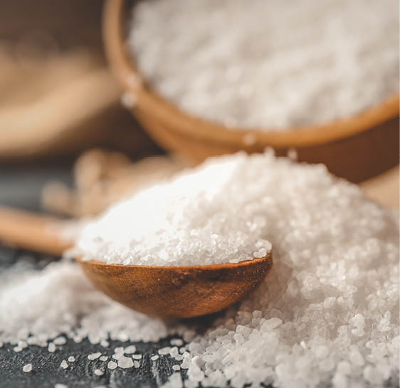 Pour salt into a wooden spoon, close-up.