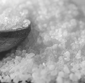 Pour salt into a wooden spoon, close-up.
